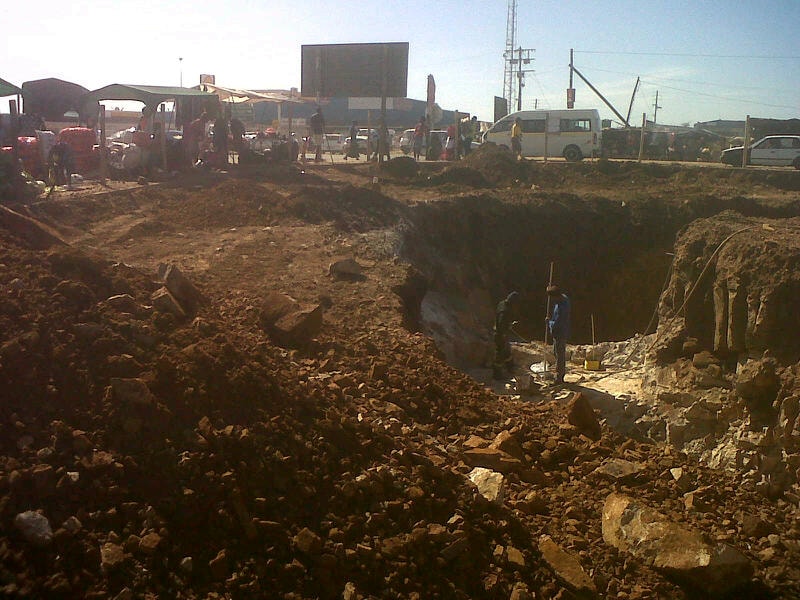 Construction site excavation with workers and equipment