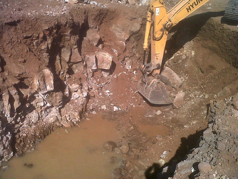 Hyundai excavator working in a blasted rock pit — Active Blasting site work