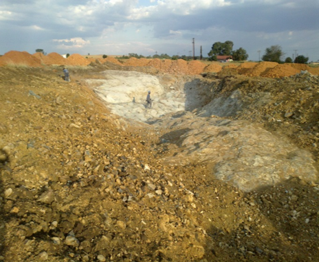 Industrial quarry excavation site with workers and equipment