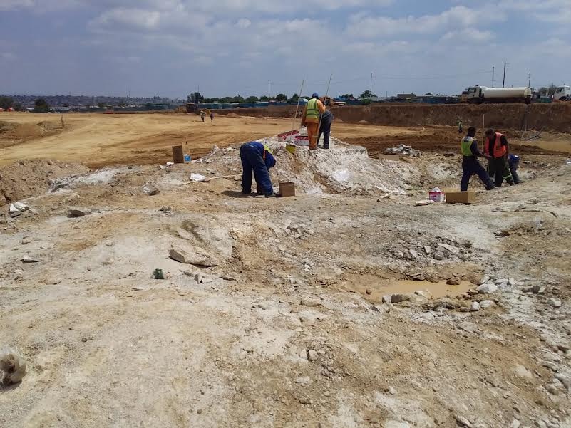 Construction workers excavating building site